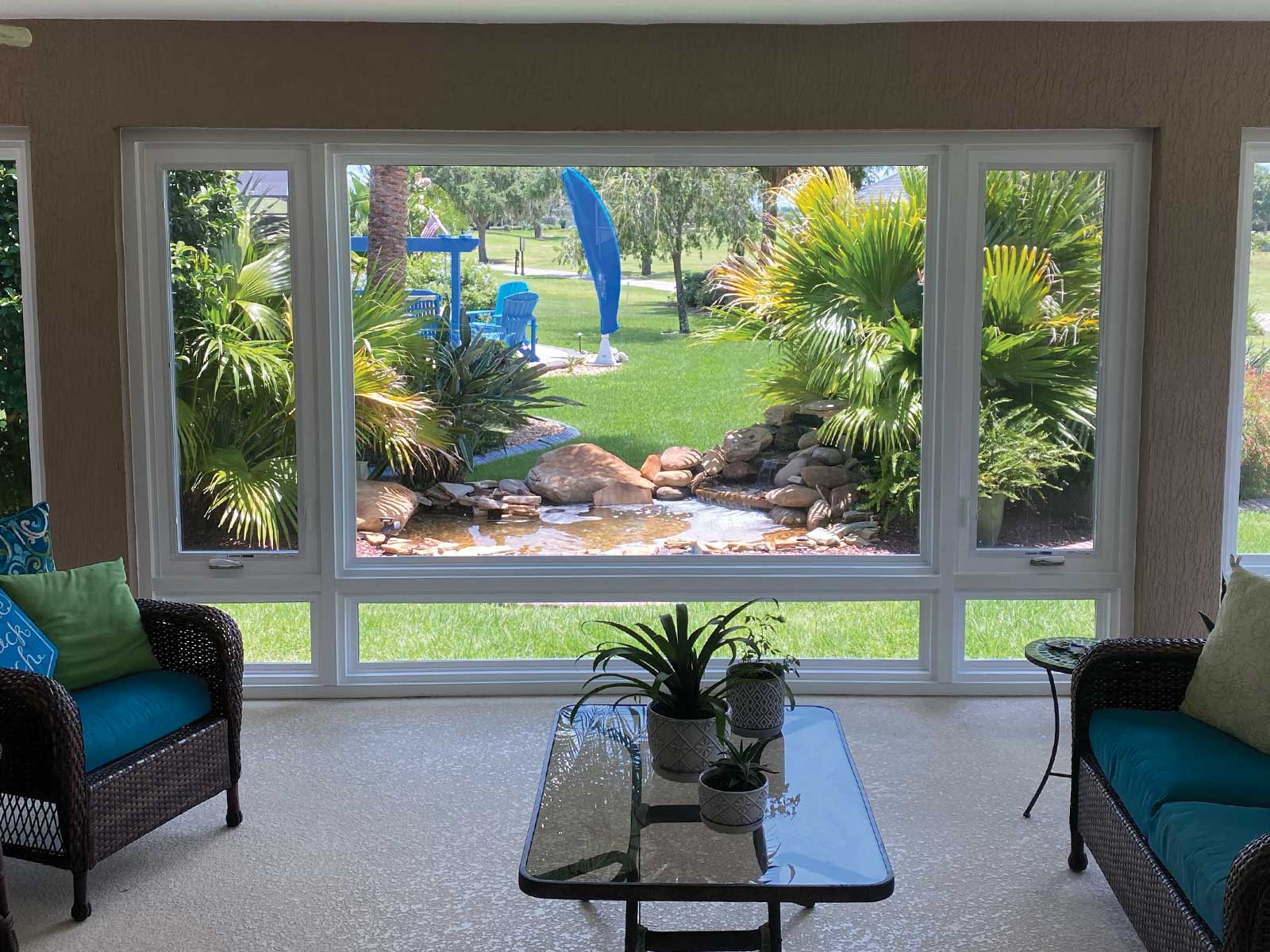 Insulated glass lanai enclosure overlooking a backyard water feature in The Villages, Florida