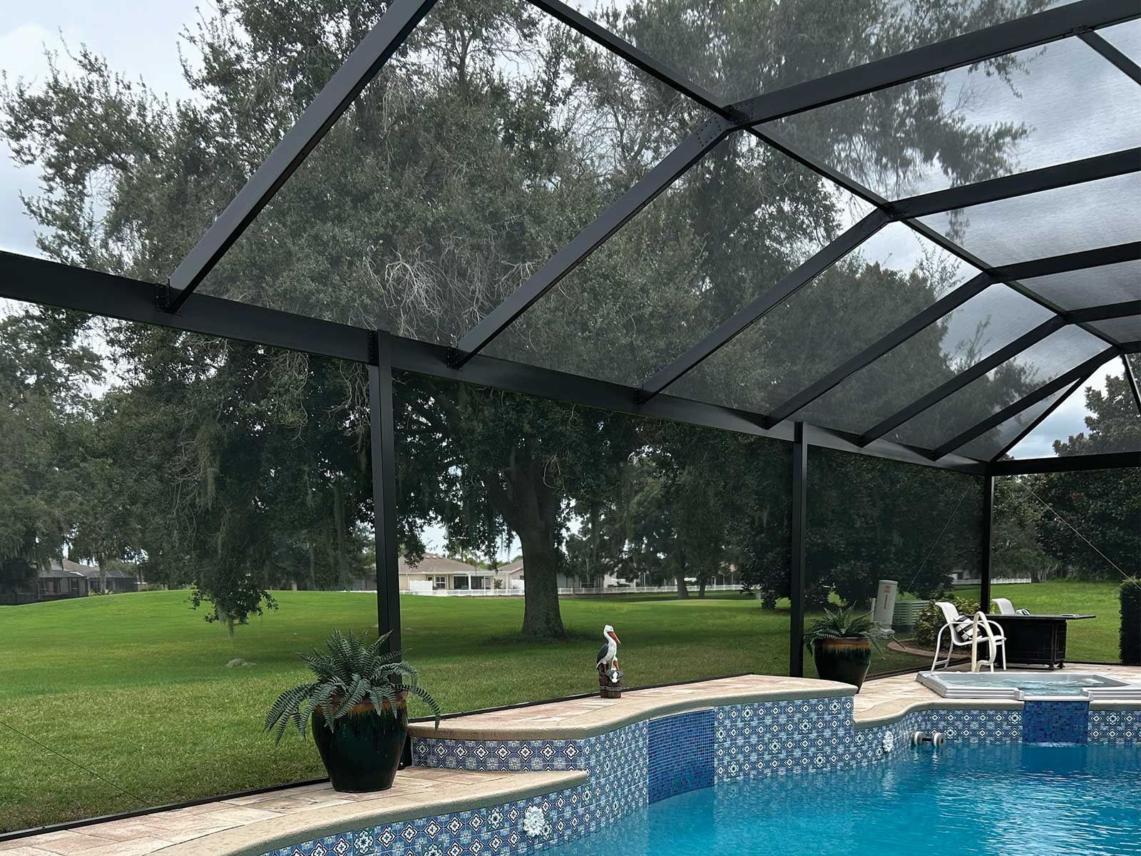 Screened pool enclosure with a gable roof and clear-span view, DNJ Construction